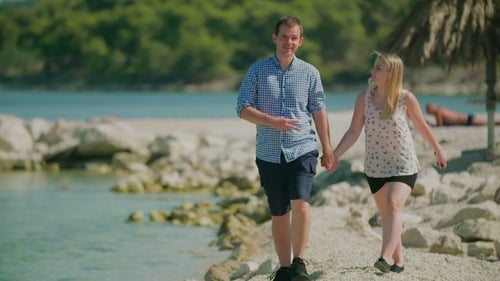 Couple Walking Hand-in-Hand on Sunny Beach