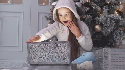 Excited Girl Opening a Magical Christmas Gift