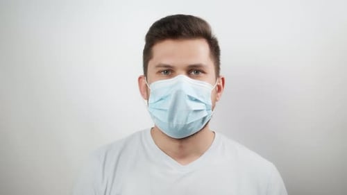 Man Takes Off Mask and Smiles