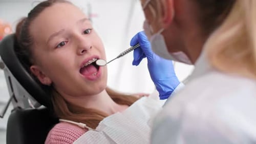 Teen Getting Dental Exam by Medical Professional