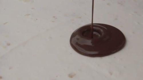 Chocolate Being Poured on Surface in Close Up