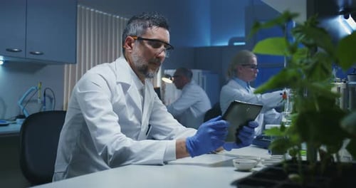 Scientist Taking a Photo of Green Plant