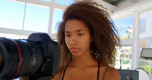 Model holding camera in photo studio 4k