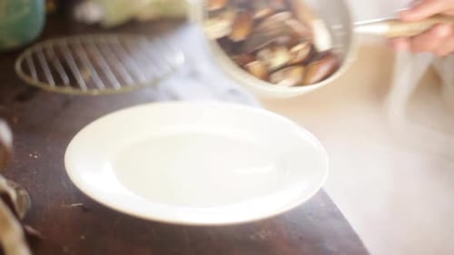 Preparing fresh steamed mussels on plate
