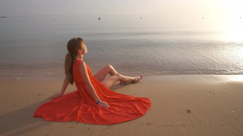 Lonely Young Woman Sitting on Ocean Sandy Beach By Seaside Enjoying Warm Tropical Evening