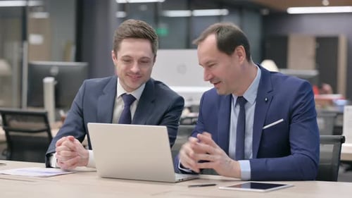 Business Men Talking in the Workplace with a Laptop