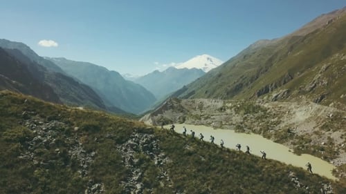 Panoramic View Hiking People Walking on Mountain with View of Lake and Snow Peak