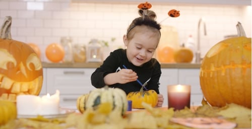 Happy Girl Painting Pumpkin