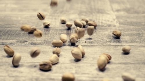 Pistachios on Falling Wooden Background