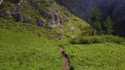 Two Tourists Go Along the Path Uphill. View From Above