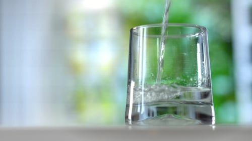 Water Being Poured Into Glass Cup