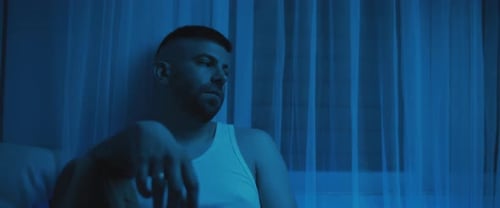 Brooding Man Sits Thoughtfully Near Window at Night