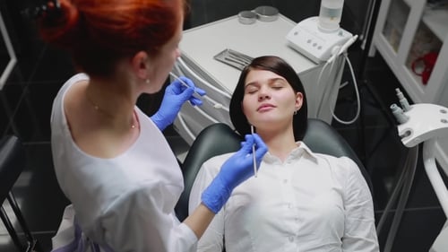 Woman Doctor Examines a Patient in a White Shirt in a White Sterile Office in Blue Gloves Conducts