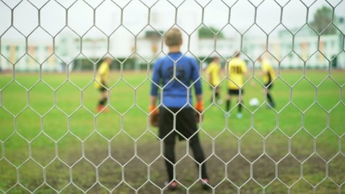 Young Boys Playing Football Soccer Game. Running Players in Blue and Yellow Uniform