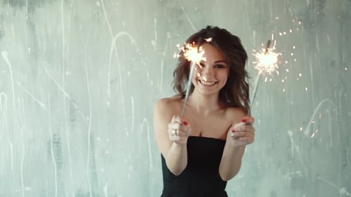 Smiling Woman Celebrates with Sparklers