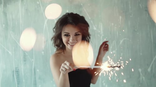 Young Woman Smiling and Holding Sparkler