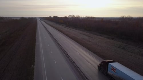 LUFTBILD: Lieferwagen fahren der Sonne entgegen. Das Auto mit den Containern fährt