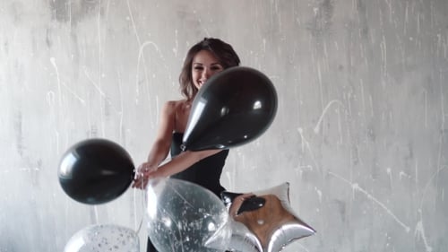 Beautiful Woman Holding Birthday Balloons in Studio