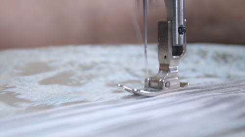 Sewing Machine Stitching White Fabric in Close-up