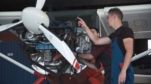 Two Mechanics Working on a Small Aircraft