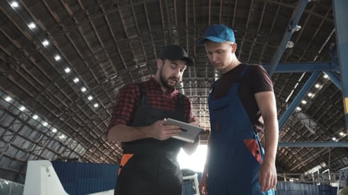 Dos hombres discutiendo en el hangar de aviones
