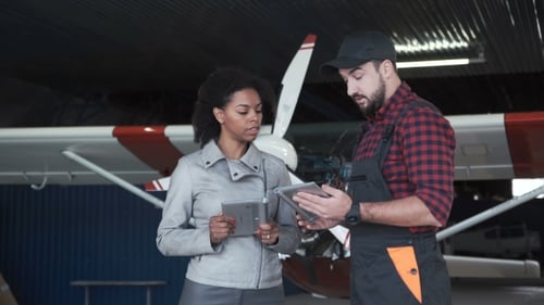Mujer hablando con el trabajador en hangar