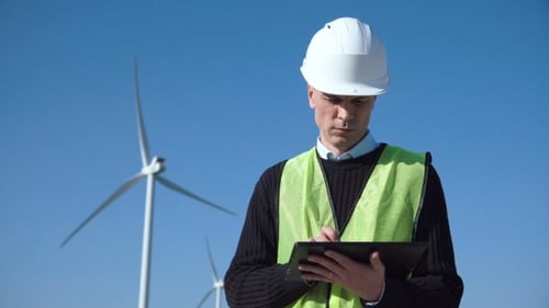 Ingenieur nutzt digitales Tablet gegen Windkraftanlagen