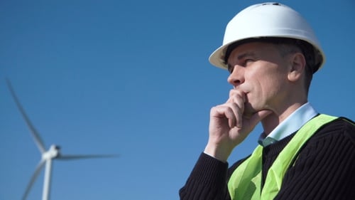 Thoughful Engineer Against Wind Turbine