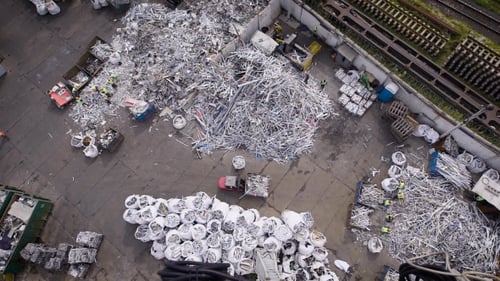 Depósito de chatarra con pilas de metal viejo, piezas de automóviles y plástico listo para reciclar en exteriores