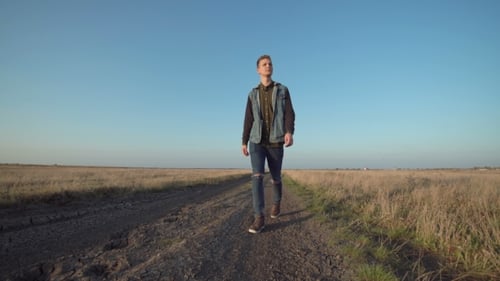 Young Man Walking Away Down a Rural Road