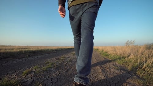 Unknown Man Walking Away Down a Rural Road