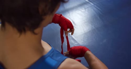 Mixed race man wrapping hands at gym