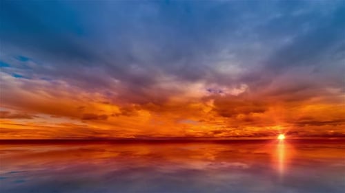 Wunderschöne Wolkenlandschaft und Sonnenuntergang, der durch die Wolken über dem See bricht. Zeitraffer 4K