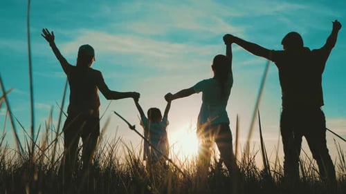 Silhouette Family Enjoying Sunset Together in Field