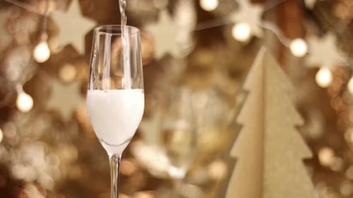 Pouring Champagne into a Glass with Festive Background
