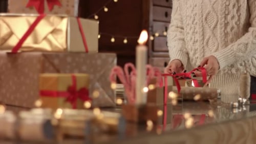 Woman Wrapping Christmas Gift with Festive Decorations