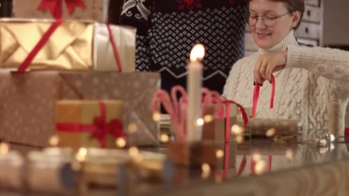 Woman Tying Ribbon on Christmas Gift