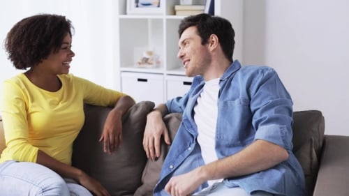 Couple Talking and Laughing on Sofa at Home