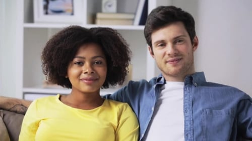 Couple Smiling Affectionately Together on Couch Indoors