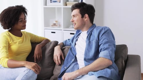 Woman and Man Chatting on Couch Indoors