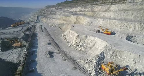 Luftbewegung über Bergbaugelände mit Baggern und Zug
