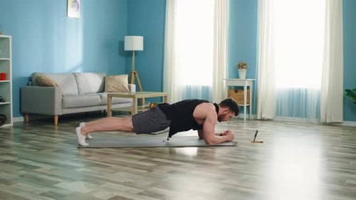 Muscular Man Doing Plank Exercise at Home