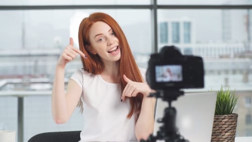 Beautiful Girl Recording Video on Camera at Office. Fashion Blogger Concept.