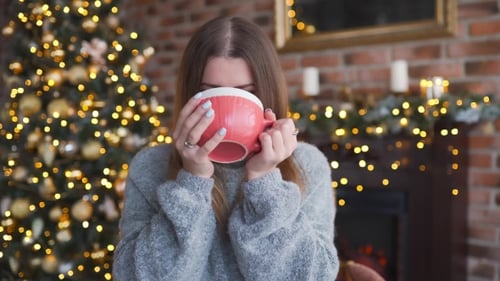 Young Woman Enjoying Christmas Cheer With Warm Drink