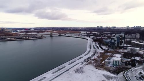 Terraplén cubierto de nieve de una gran ciudad en la orilla de un río tranquilo