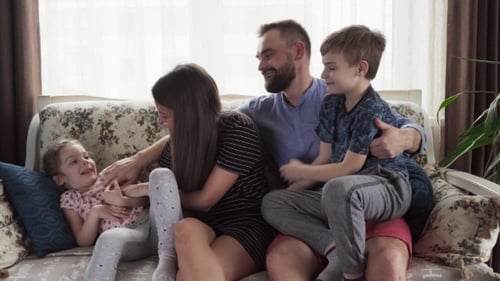 Happy Family Relaxing Together on Sofa at Home