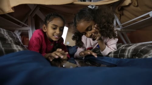 Young Girls Playing on Tablet in Blanket Fort