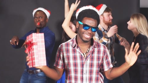 Young Multi-ethnic Friends Dancing at Christmas Party in Studio.