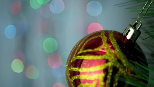 Festive Red Ornament on Christmas Tree with Bokeh Lights