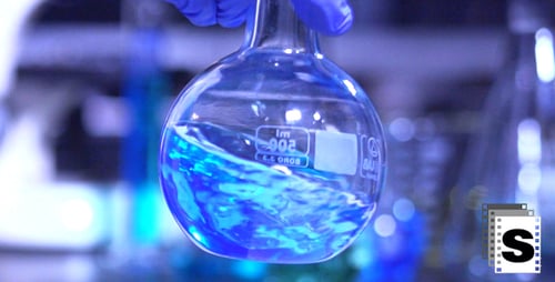 Blue Liquid Being Mixed in Laboratory Flask